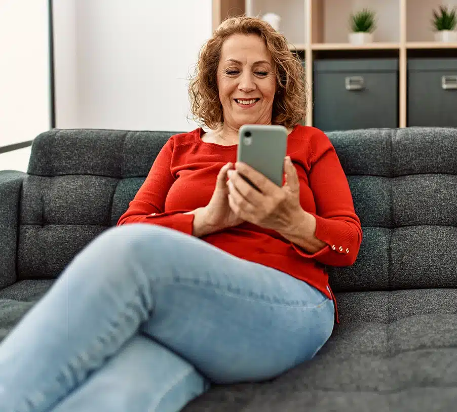 Mulher de aproximadamente 45 anos respondendo missão ao vivo do PiniOn enquanto assiste televisão.