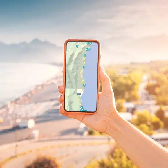 Mão segura celular com mapa de geolocalização aberto