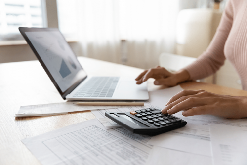 mulher avalia preço na calculadora para investir em pesquisa
